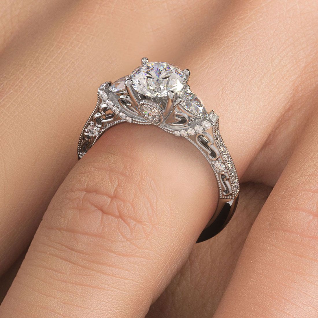 Milgrain vintage style engagement ring with round center and pear side diamonds worn on finger, elegant and timeless design in 18KT white gold. Filigree detailing and handcrafted design from Global Sky Diamonds, 44W 47th St Booth GF-10, NYC Diamond District. Classic bridal jewelry. Website: globalskydiamond.com. IG: @globalskydiamonds TikTok: @global.sky.diamonds. #Mazalito #NYCJeweler
