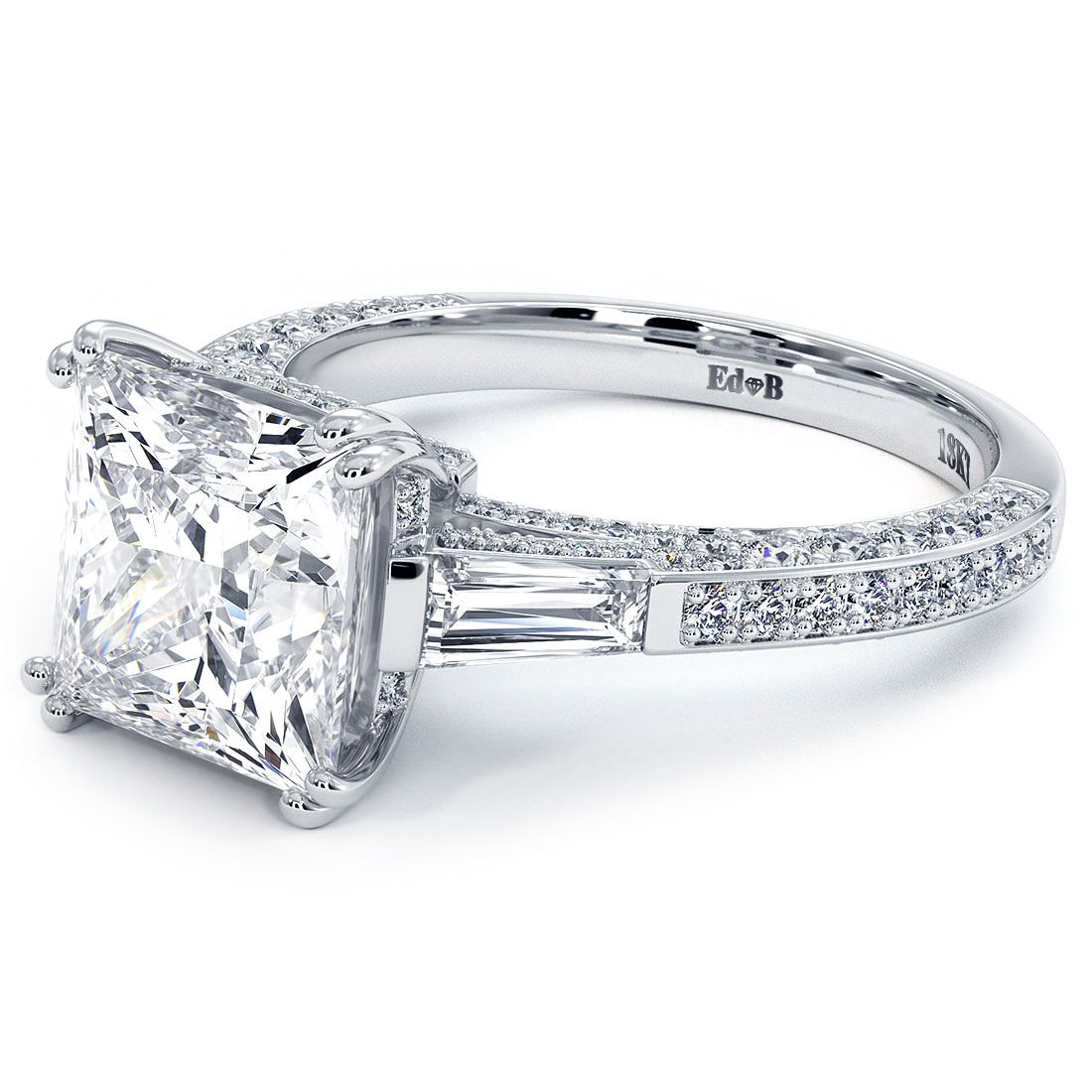 Angled close-up of princess cut diamond engagement ring with micropavé diamond band, tapered baguette side stones, and 18KT white gold setting. Classic yet luxurious three-stone look for a 3.0ct center. From Global Sky Diamonds, 44W 47th St Booth GF-10, NYC Diamond District. globalskydiamond.com @globalskydiamonds @global.sky.diamond