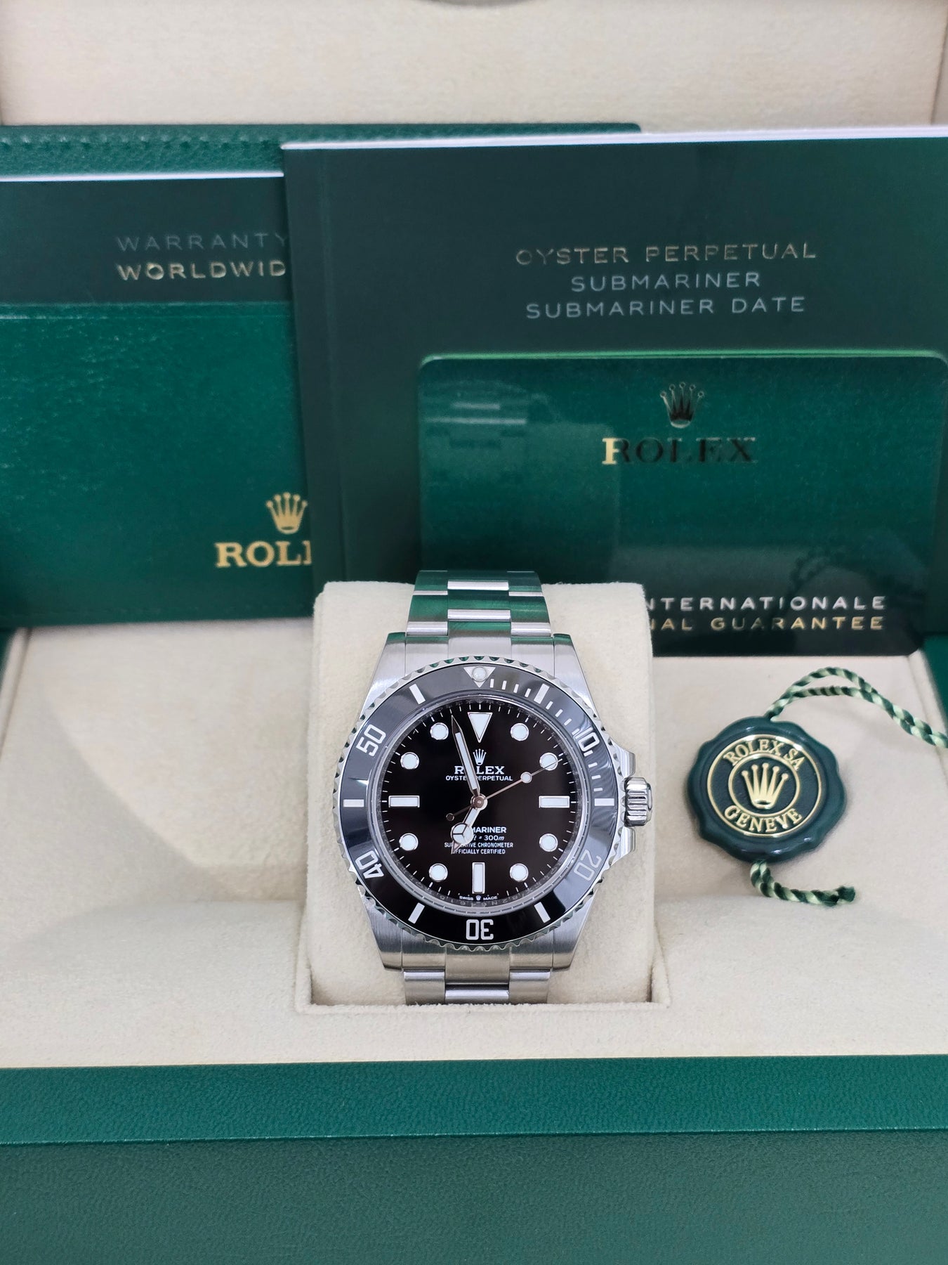 Display of complete pre-owned Rolex Submariner 114060 set with box and appraisal – like-new 2018 No Date Submariner for sale at Global Sky Diamonds – globalskydiamond.com