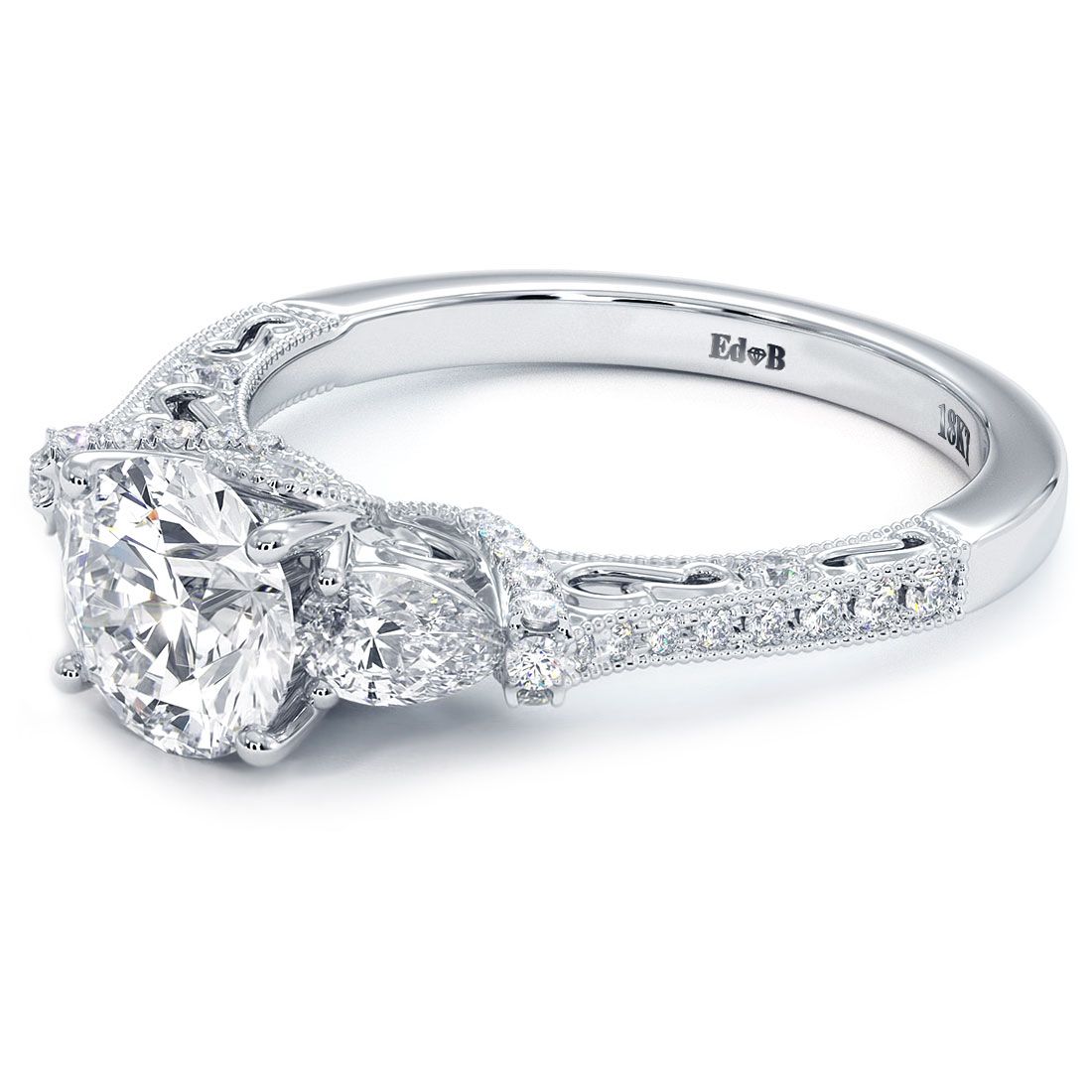 Close-up angled view of vintage milgrain three-stone diamond engagement ring with round brilliant center and pear-shaped side stones, pave shank in 18KT white gold. Exclusive design from Global Sky Diamonds, located at 44W 47th St Booth GF-10 in NYC's Diamond District. Visit globalskydiamond.com or follow @globalskydiamonds on Instagram, @global.sky.diamonds on TikTok. #Mazalito